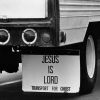 White semi truck trailer with white "Jesus is Lord" mudflaps hanging behind its tires