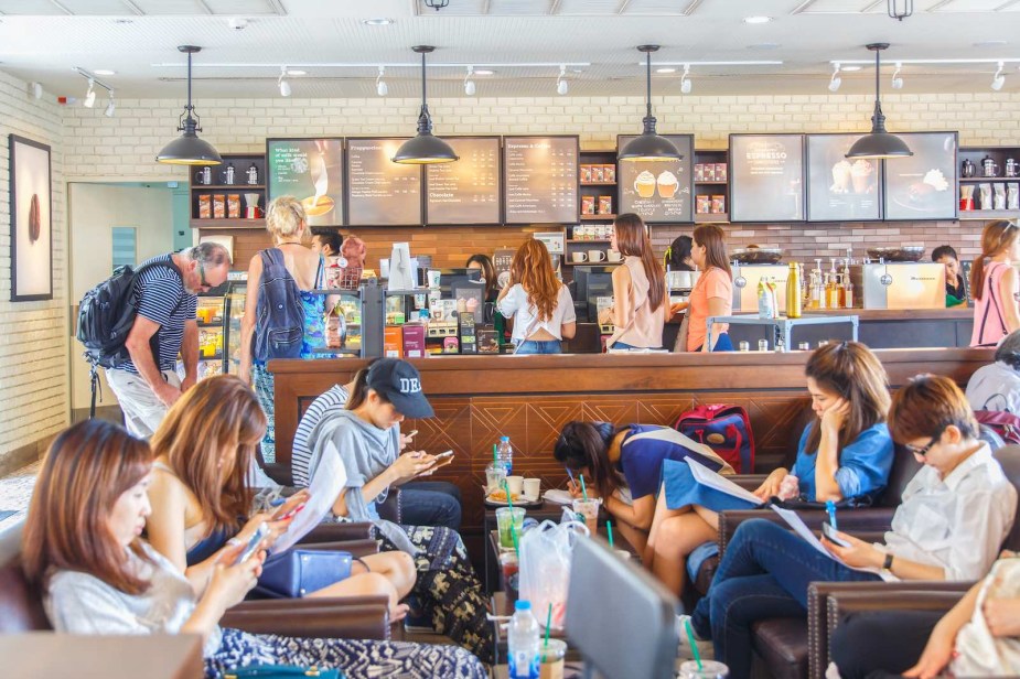 Customers sit in a Starbucks cafe and drink their coffee