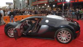 Tom Cruise tries to awkwardly get out of his Bugatti Veyron supercar