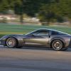 A gray Chevrolet Corvette Z06 shows off its side profile as it cruises down a road.