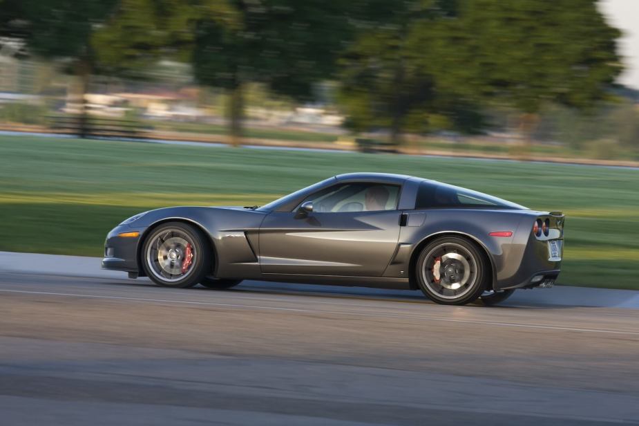 A gray Chevrolet Corvette Z06 shows off its side profile as it cruises down a road.