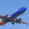 A Southwest Airlines Boeing commercial plane taking off with landing gear engaged facing right front profile view