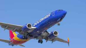 A Southwest Airlines Boeing commercial plane taking off with landing gear engaged facing right front profile view