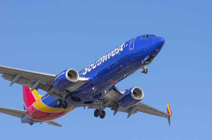 A Southwest Airlines Boeing commercial plane taking off with landing gear engaged facing right front profile view