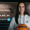 Professional basketball player Caitlin Clark shown holding a basketball with long dark hair and white Nike hoodie for Buick's "See Her Greatness" campaign in 2023