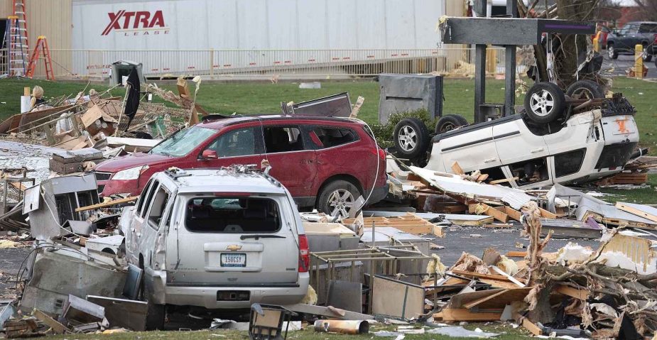 Three SUVs are shown heavily damaged from a tornado in Indiana in 2024, a white SUV is flipped over