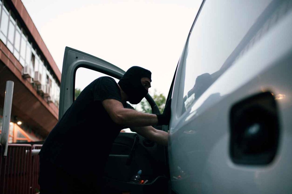 Image showing a masked man entering a white vehicle carjacking depiction