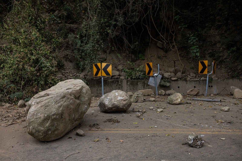 A mountainous road in Hualien County, Taiwan, is covered in boulders and rockfall from the 2024 earthquake in close profile view