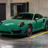 A green Porsche Turbo S parked in a parking garage in left front angle view