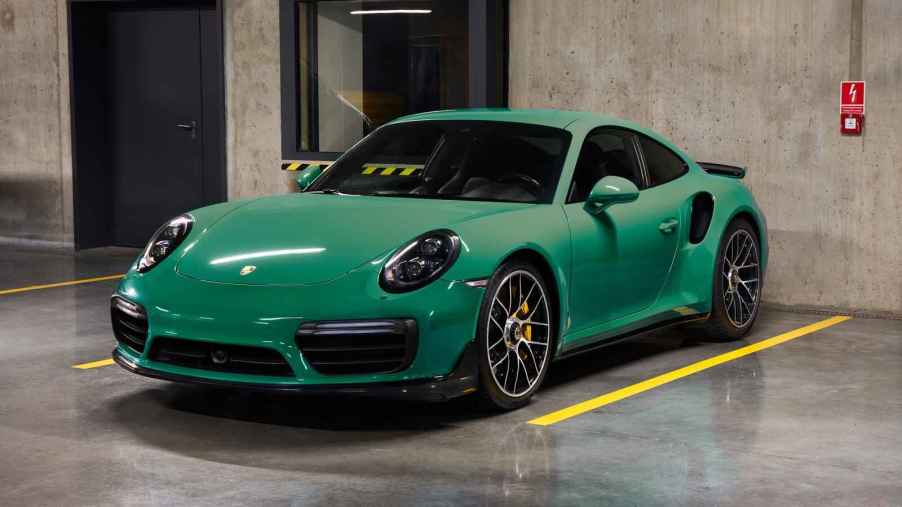 A green Porsche Turbo S parked in a parking garage in left front angle view
