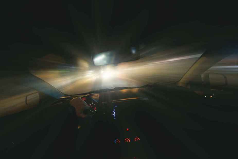 Dark image from a car interior driving fast blurred lights possible road rage depiction