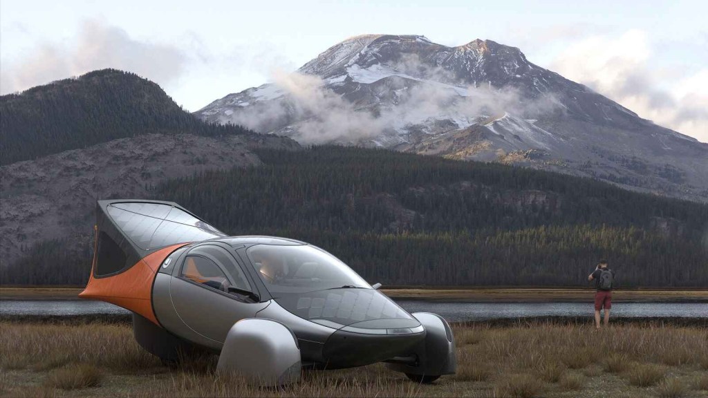 A rendering of the Aptera Launch Edition solar-powered EV parked in right front angle view left frame rear camping tent accessory installed water and mountains in background with driver standing at water right of frame