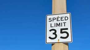 A "speed limit 35" sign posted on a brown pole with a blue background
