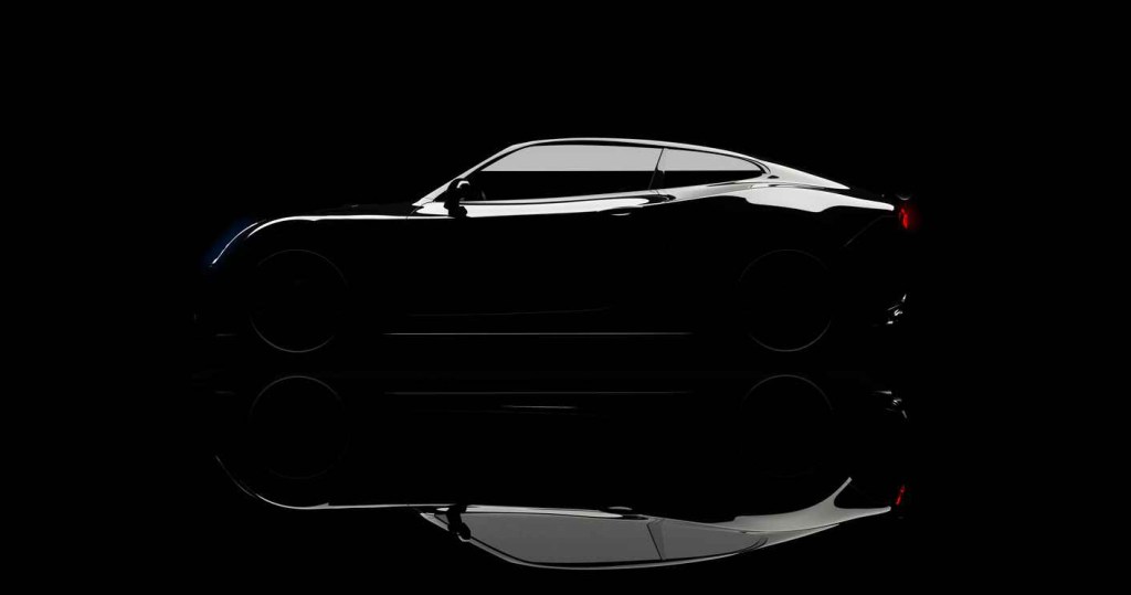 Silhouette of a black sports car parked in dark setting in left profile view