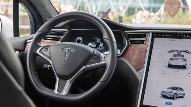 The front dash view and steering wheel of a white Tesla Model X