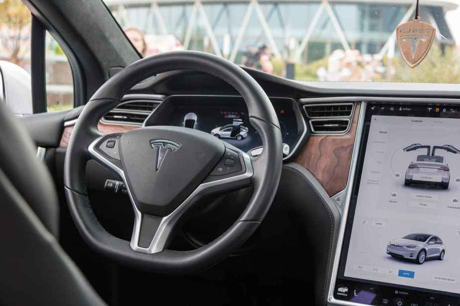 The front dash view and steering wheel of a white Tesla Model X