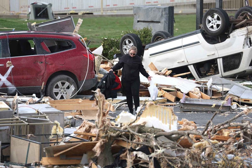 A white SUV shown flipped over next to a damaged red SUV amid tornado debris in Indiana, U.S., 2024