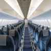 The empty cabin of a commercial plane blue seats with cabin lights turned on