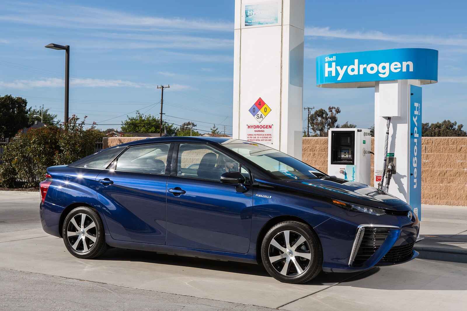 A blue Gen 1 2016 Toyota Mirai hydrogen car parked at a refueling station