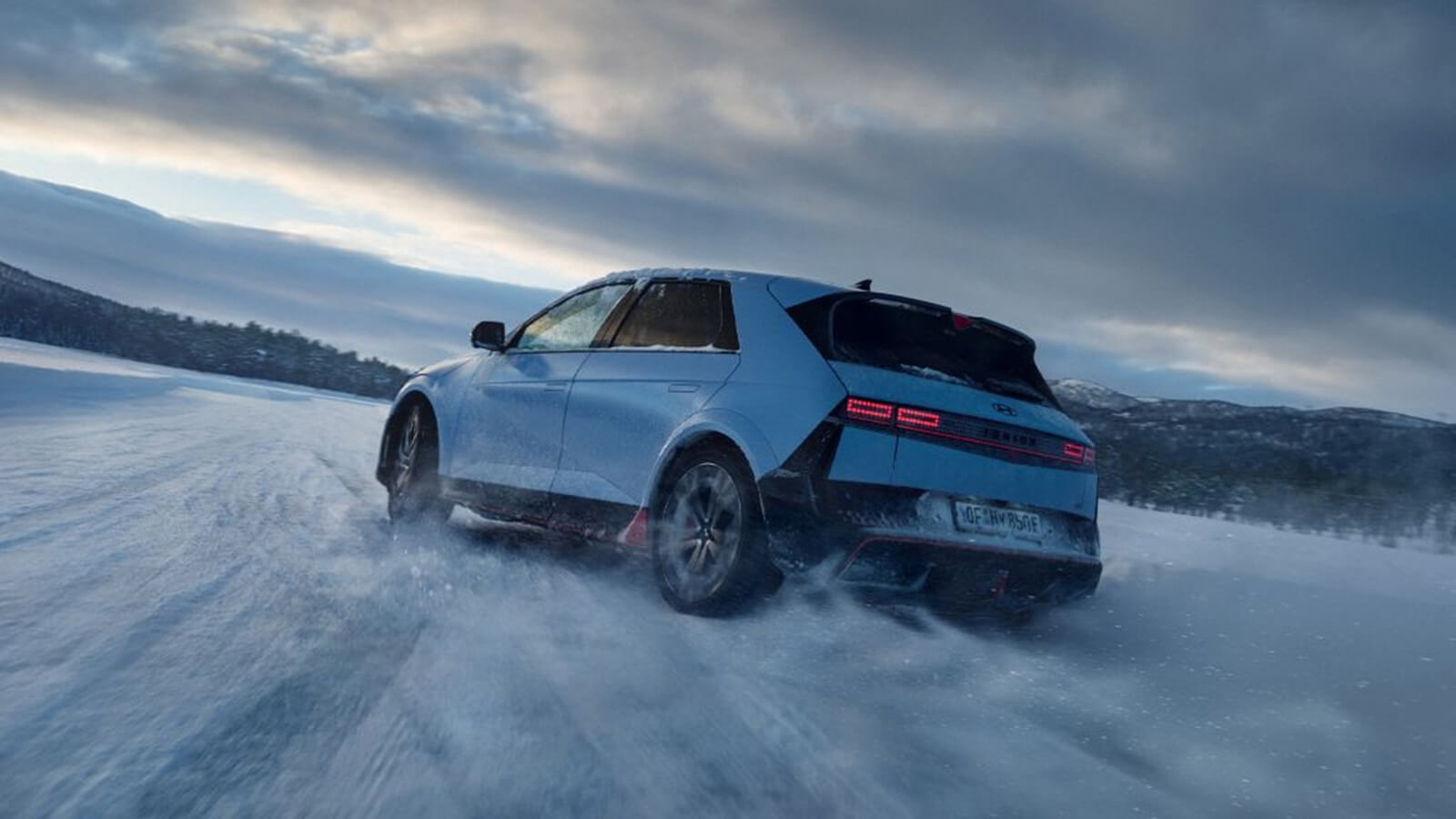 A 2025 Hyundai Ioniq 5 N shows off its rear-end styling as it kicks up snow. 