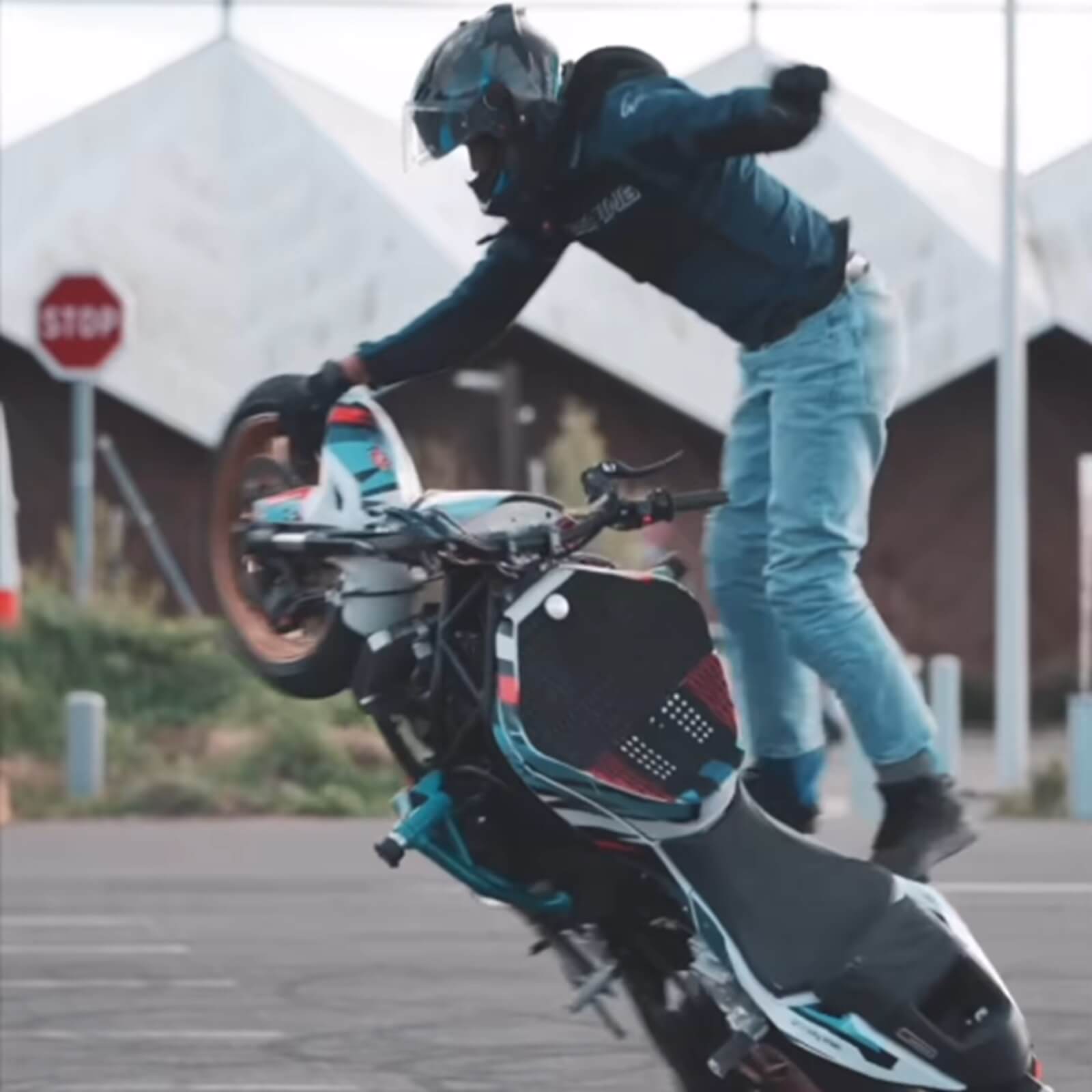 Motorcycle stunt rider Benjamin Baldini stands on a Yamaha mid-trick.