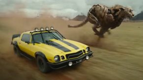 A yellow and black Bumblebee Camaro drives off road in 'Transformers: Rise of the Beasts'.