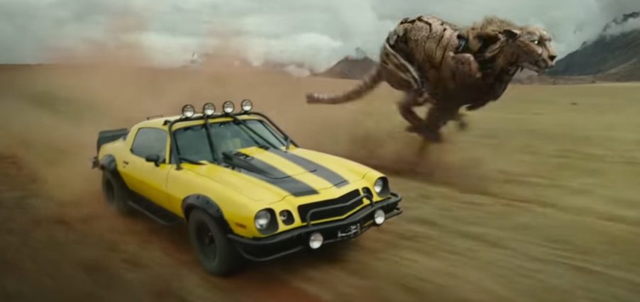 A yellow and black Bumblebee Camaro drives off road in 'Transformers: Rise of the Beasts'.