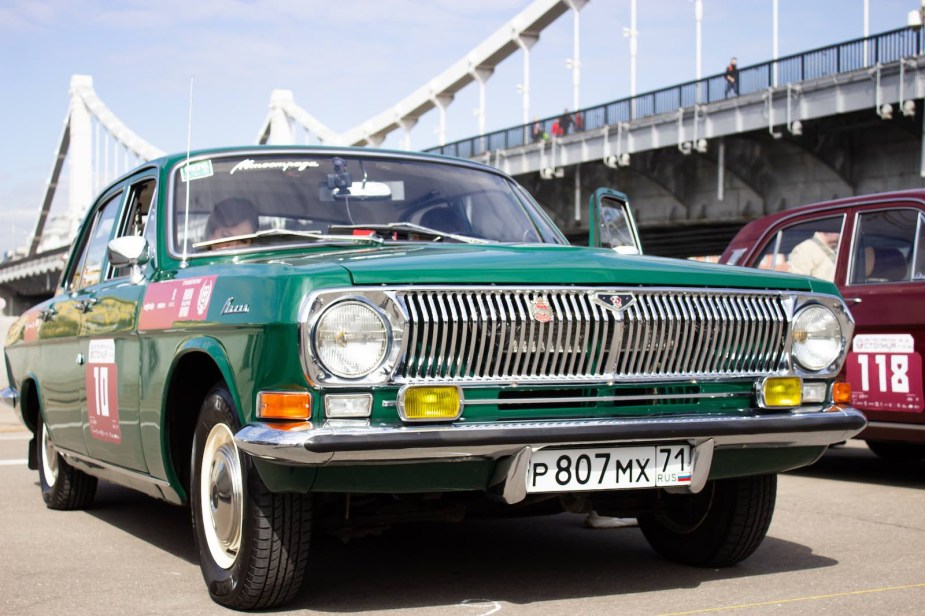 Classic Russian Gaz-24 race car parked in the pit lanes of a track.