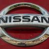 Silver Nissan logo on a red truck.