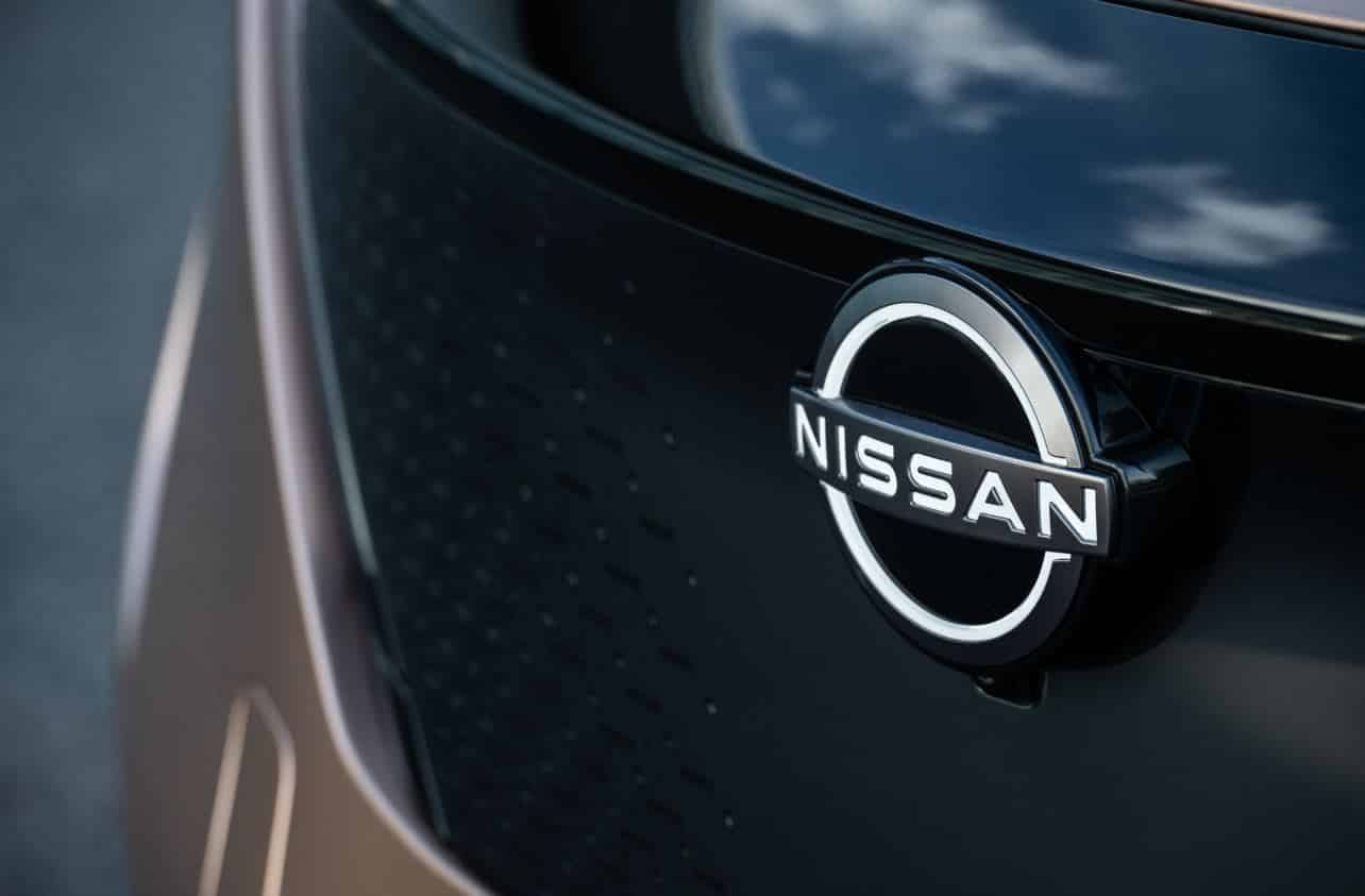 The Nissan badge on the front bumper of a car