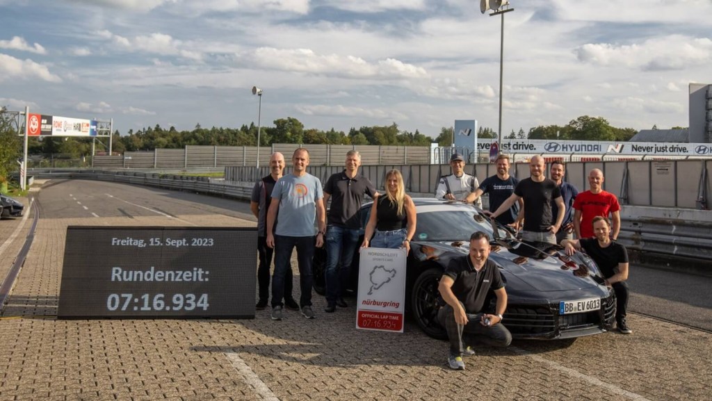 The Porsche team celebrates a successful lap of the 911 Hybrid on the Nürburgring.