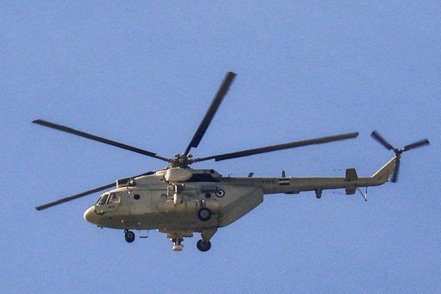 Russian-built Mi-8 helicopter flying in front of a blue sky.