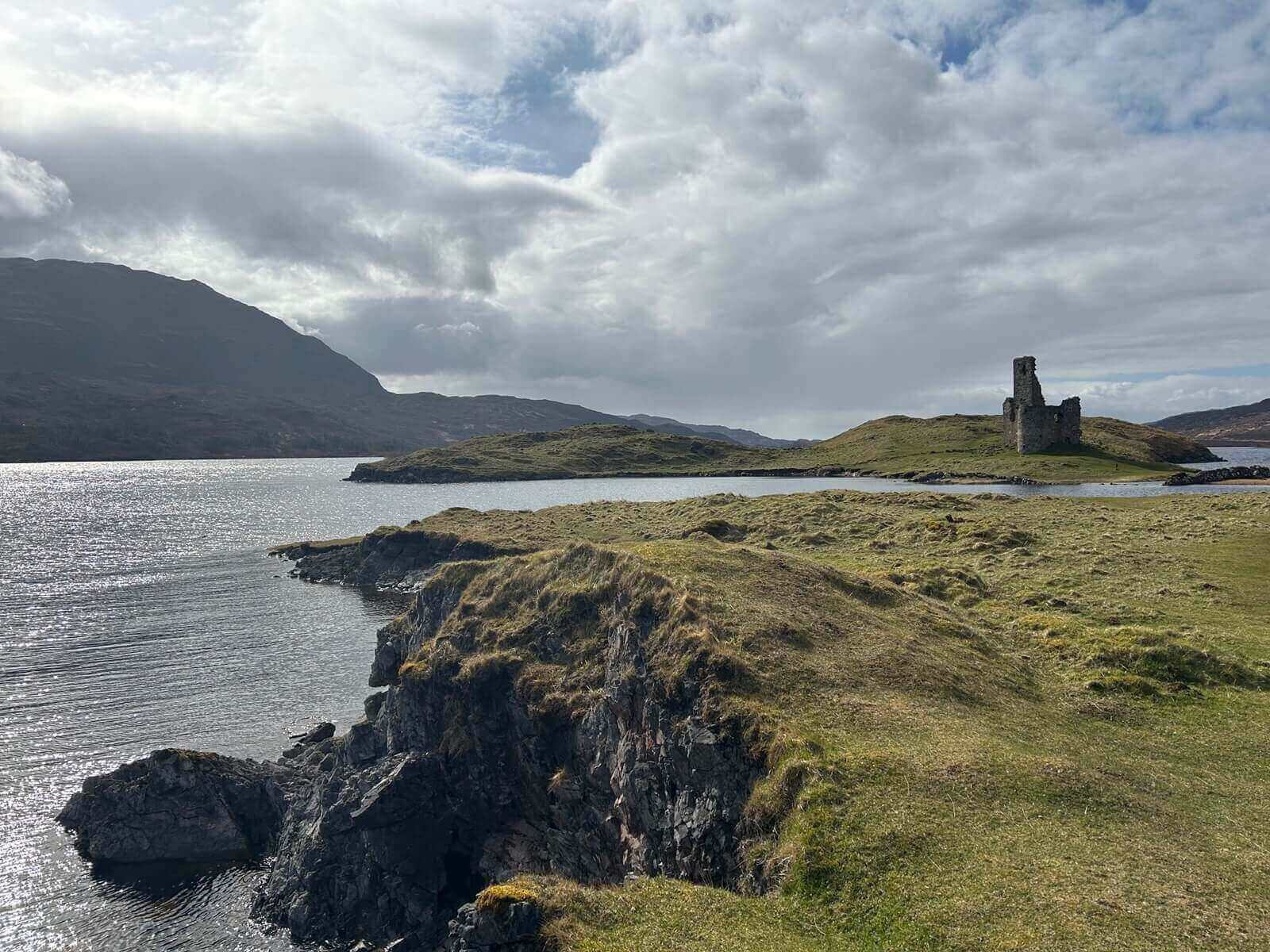 Ruins jut out from a loch's shores. 