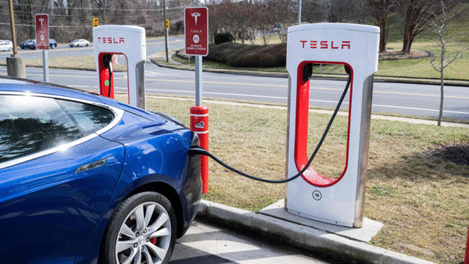 Blue Tesla Plugged Into a Supercharger.