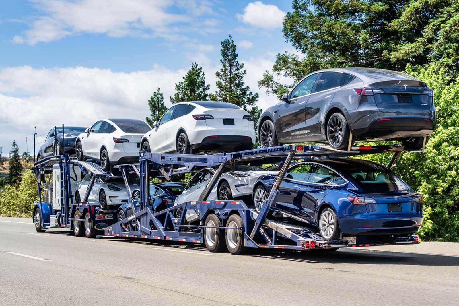 Teslas on a being shipped on a car transporter.