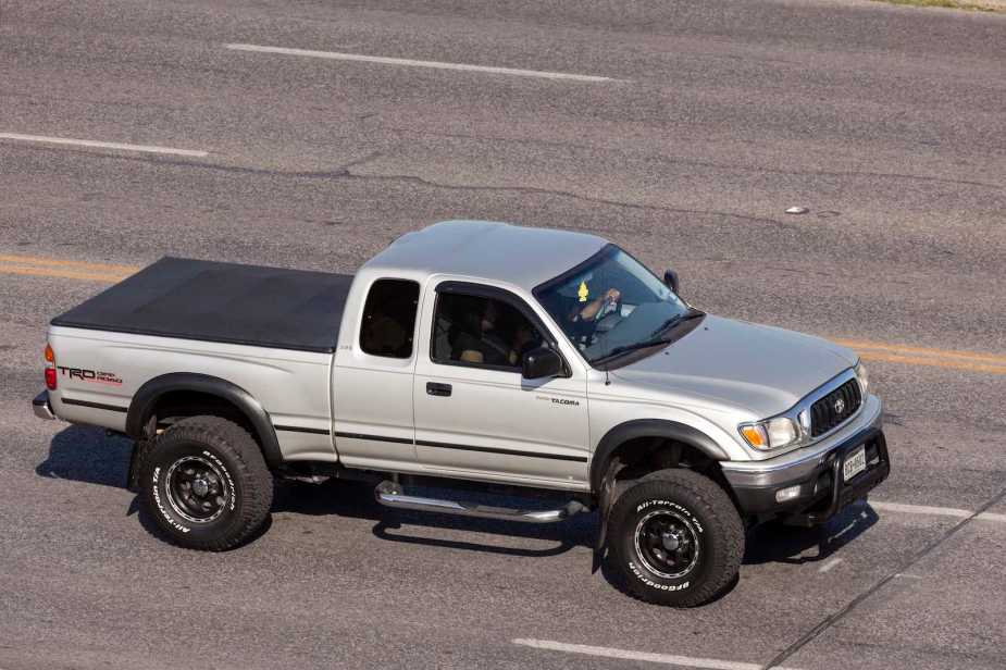 Silver Toyota pickup truck driving down the highway.
