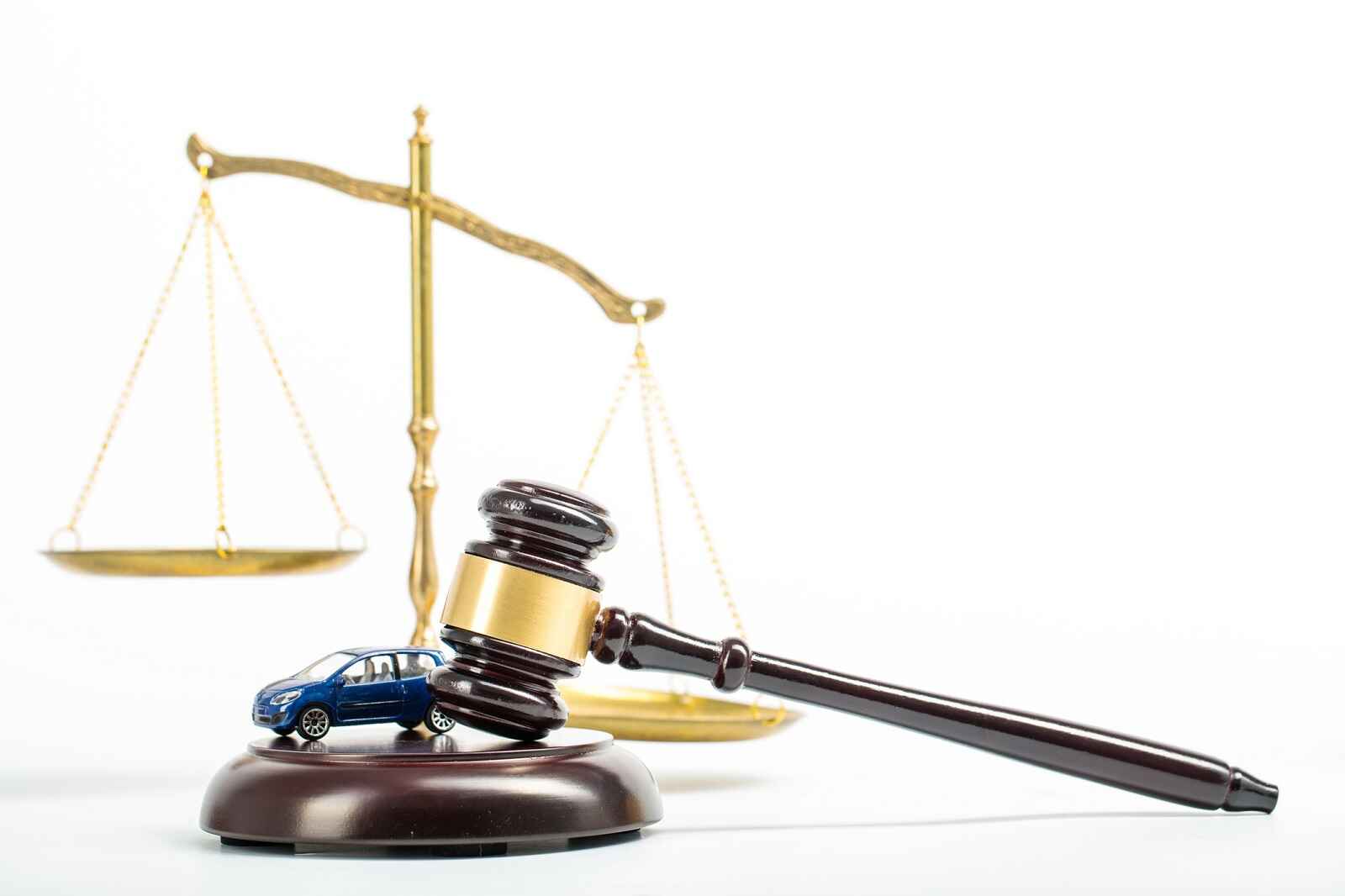 A court gavel shown with a toy car and scale in the background ways to lose driver's license