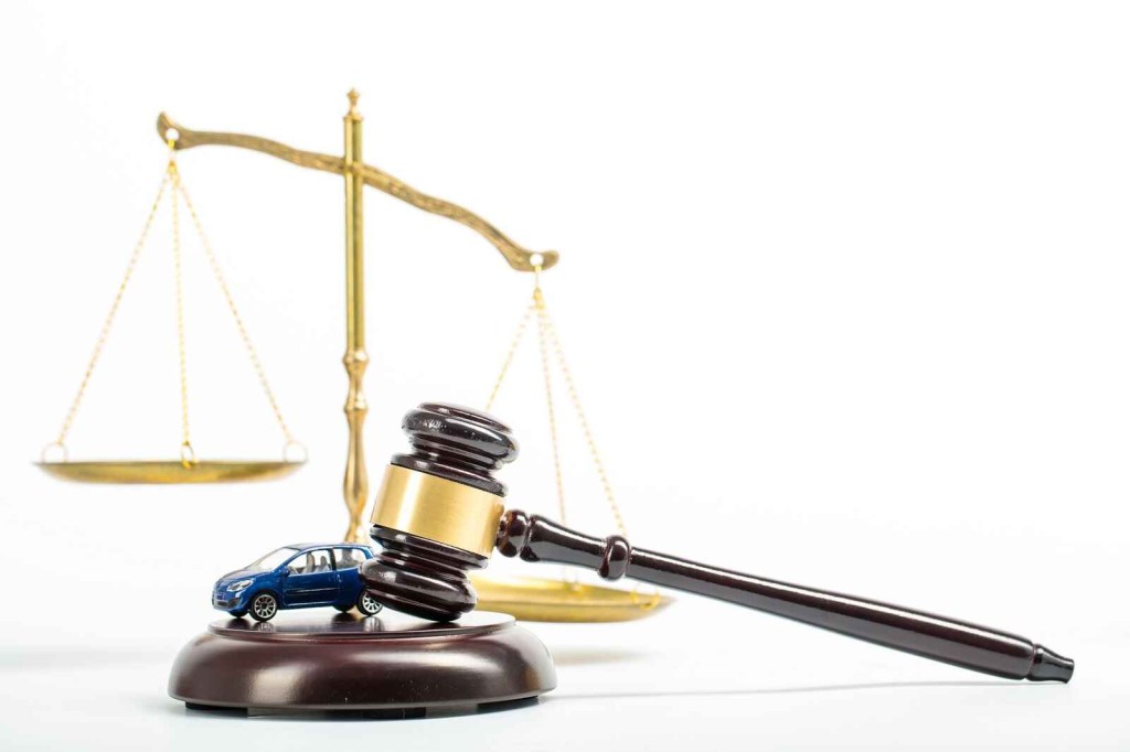 A court gavel shown with a toy car and scale in the background ways to lose driver's license