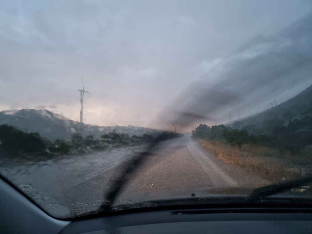 Rainy tornado storm shown through driver windshield close view