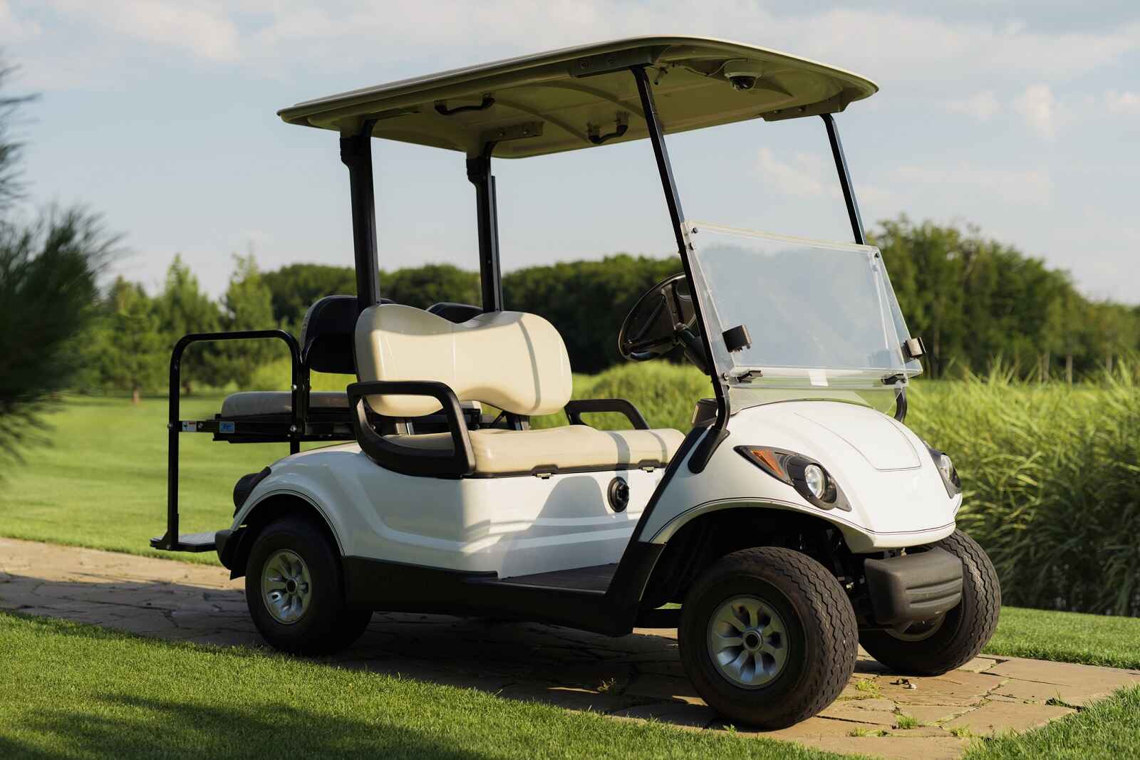 A white golf cart parked at a golf course