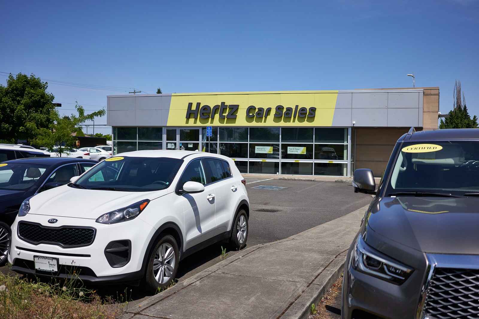 A Hertz car sales building with cars parked outside