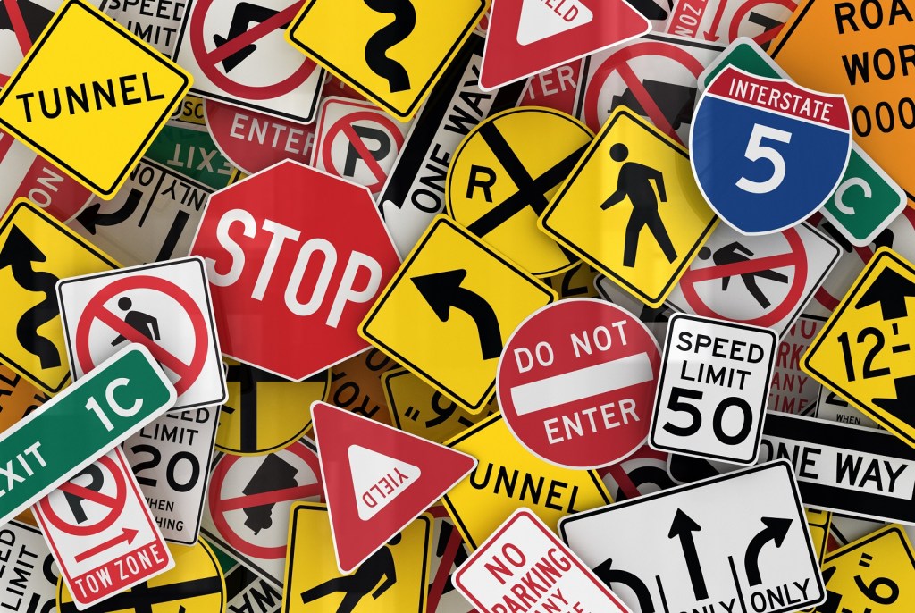 A digital rendering of many American street signs piled on top of each other