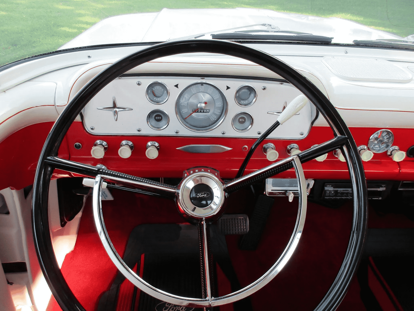 The steering wheel and dash of a 1960 Ford F-100 truck with a three-speed manual transmission