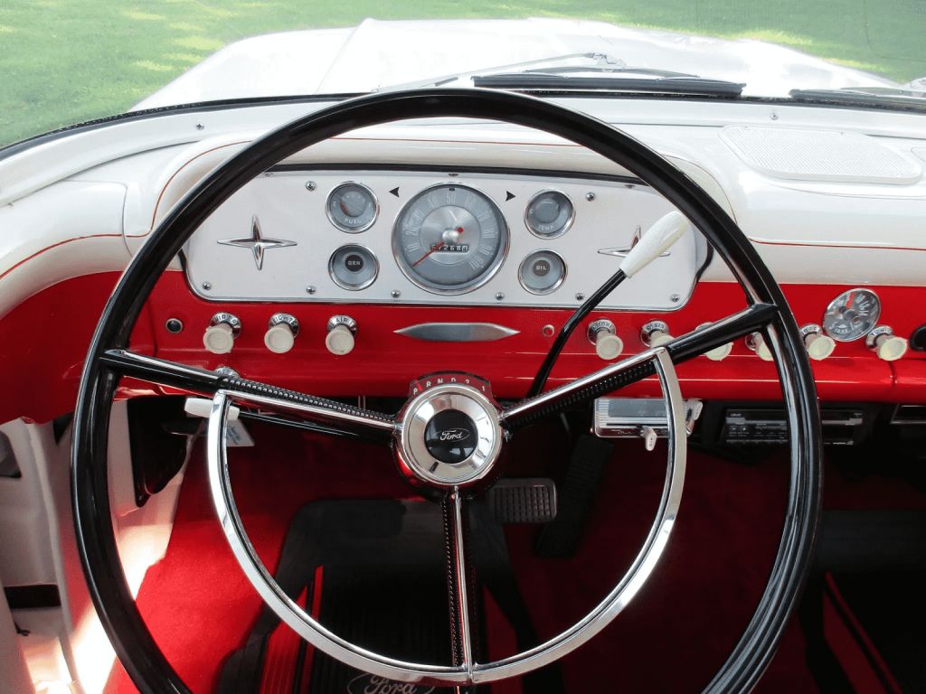 The steering wheel and dash of a 1960 Ford F-100 truck with a three-speed manual transmission