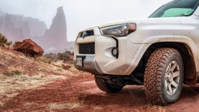 A white 2016 Toyota 4Runner parked in left front corner angle view facing left frame with Moab in background