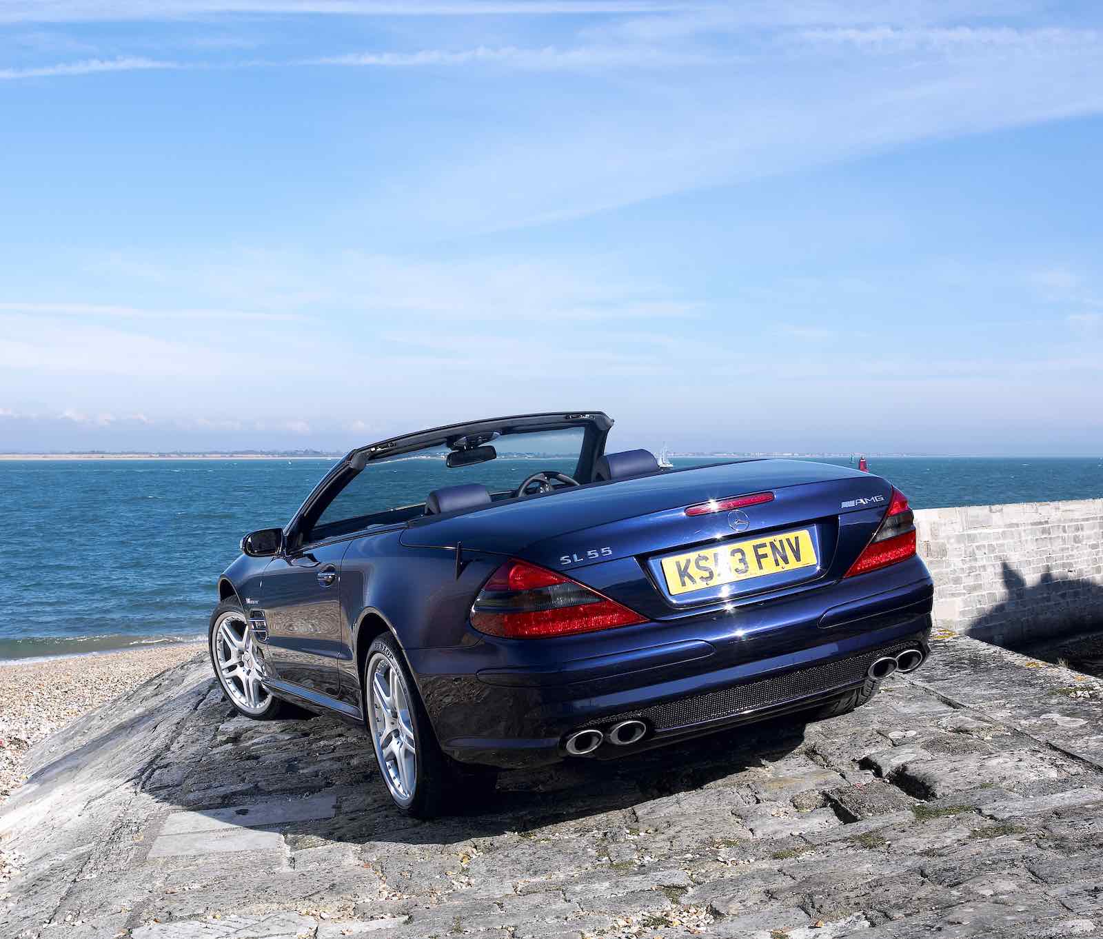 Rear of a Mercedes-Benz convertible, the ocean visible in the background.