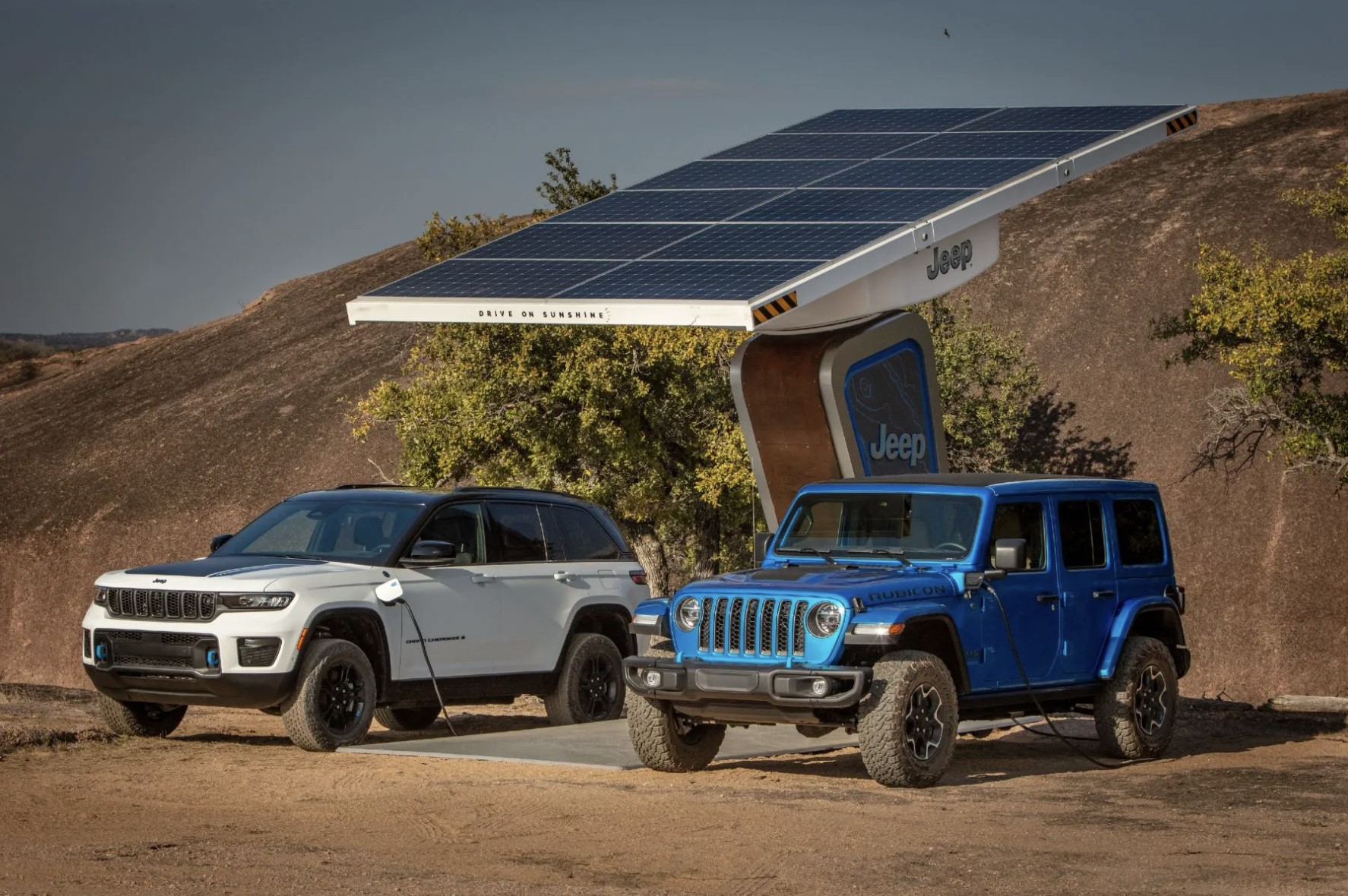 The 2024 Jeep Wrangler 4xe and Jeep Cherokee 4xe at a charging station 