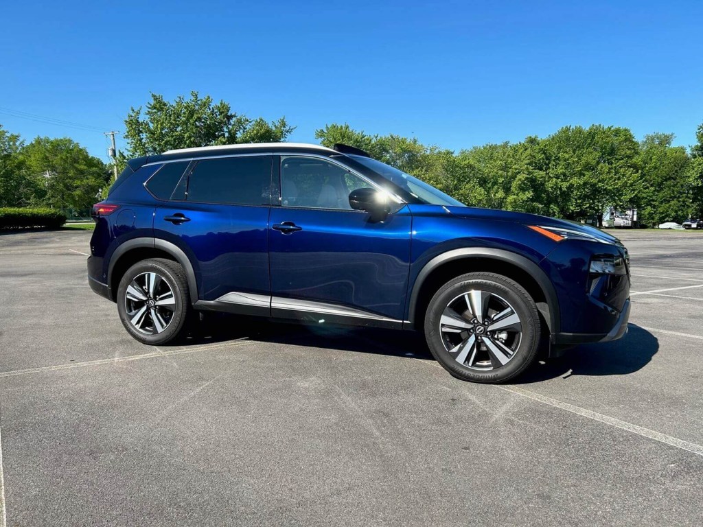 A blue 2024 Nissan Rogue SL AWD shows off its side profile.