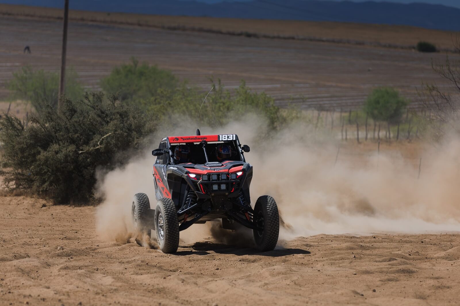 Craig Scanlon kicks up dirt in a red Polaris Factory Racing RZR Pro R Factory model.