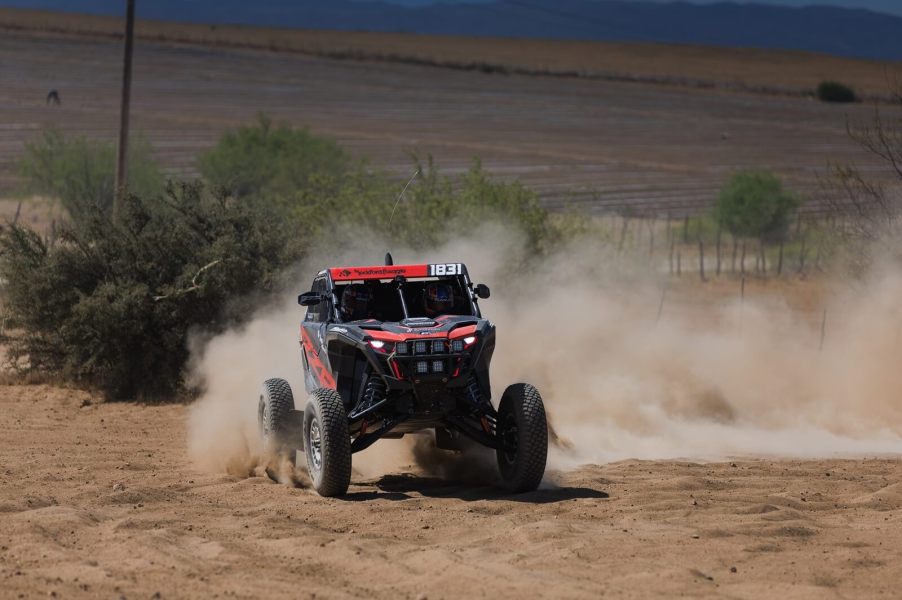 Craig Scanlon kicks up dirt in a red Polaris Factory Racing RZR Pro R Factory model.